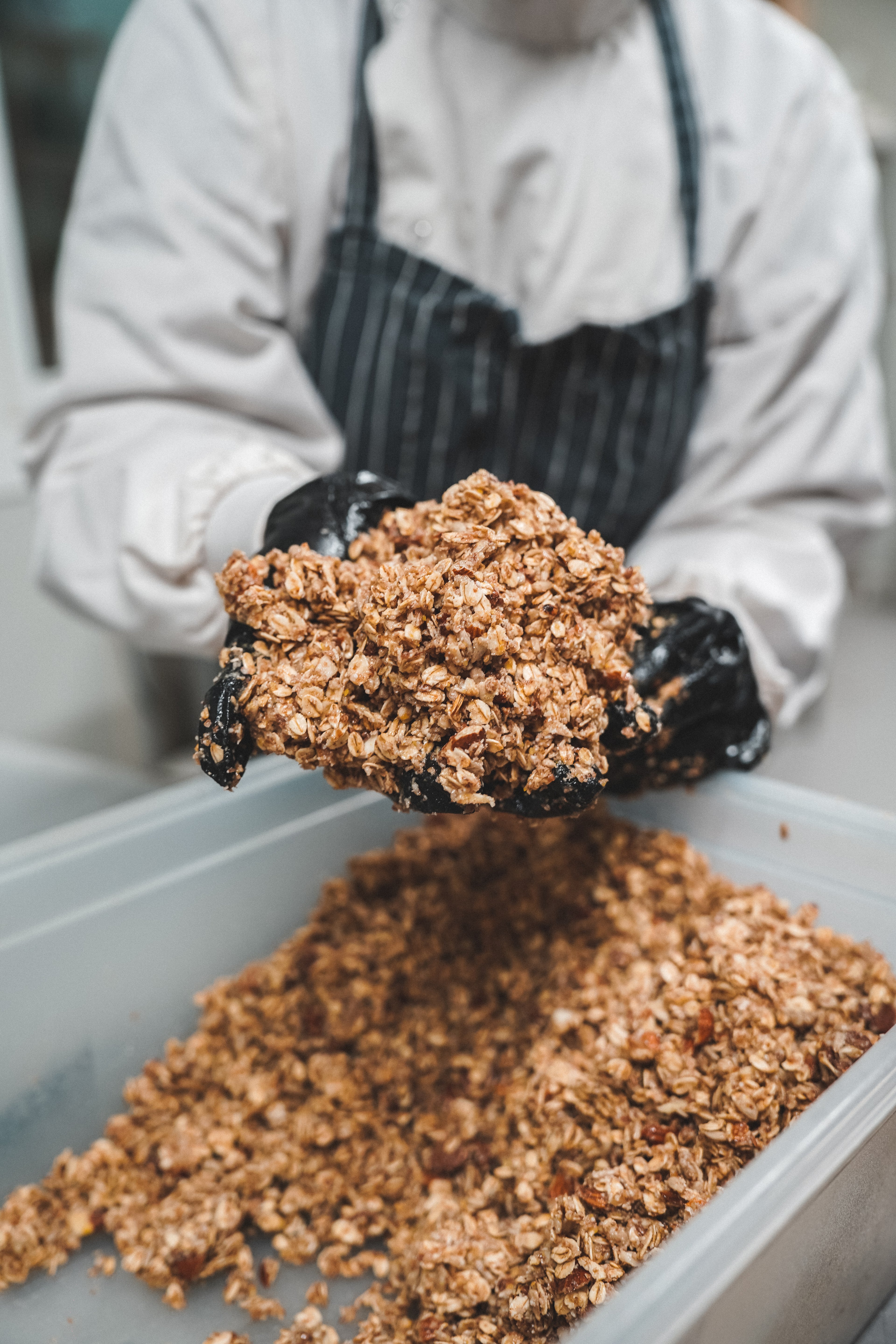 une personne tient entre ses mains du granola avant cuisson